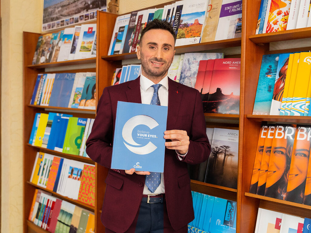 Marco Di Filippo con un catalogo di viaggi nell'agenzia Granato Viaggi